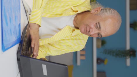 Vertical-video-of-Home-office-worker-old-man-happy-and-smiling.